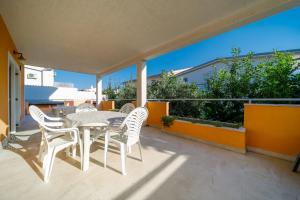 a patio with a table and chairs on a balcony at Apartments Bozena in Krk