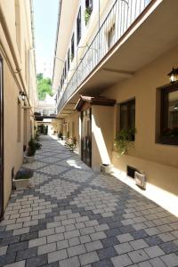 an alley between two buildings with plants on the side at Safrano Palace in Braşov
