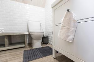 La salle de bains est pourvue de toilettes et d'une serviette sur la porte. dans l'établissement Family house Vila Rica, à Ricieliai