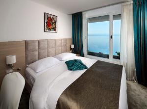 ein Schlafzimmer mit einem großen Bett mit einem großen Fenster in der Unterkunft Grand Hotel Adriatic II in Opatija