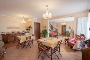 jadalnia ze stołami i krzesłami oraz kuchnia w obiekcie AgriB&B Corte Burchio w Adrii