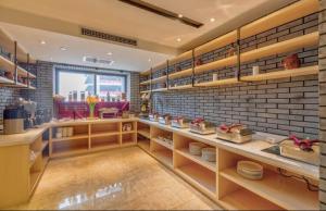 una cucina con scaffali e un muro di mattoni di Atour Hotel Xi'an Gaoxin Tangyan Road Branch a Xi'an