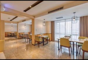una stanza con tavoli e sedie e una grande finestra di Atour Hotel Xi'an Gaoxin Tangyan Road Branch a Xi'an