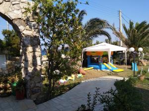 a backyard with a playground with a tent and slides at Το πετρινο in Agia Marina Mikrolimanou