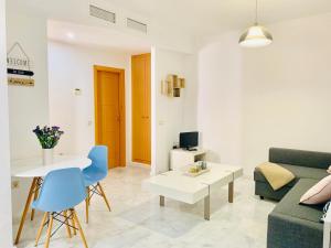 ein Wohnzimmer mit einem Sofa und einem Tisch in der Unterkunft Homely Málaga Parras con terraza interior in Málaga