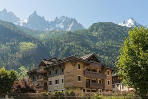 a building with mountains in the background at Residence La Ginabelle - maeva Home in Chamonix-Mont-Blanc