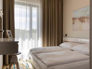 ein Schlafzimmer mit einem Bett und einem großen Fenster in der Unterkunft VacationClub – Baltic Park Molo Apartament C104 in Świnoujście