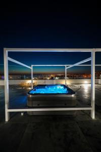 a hot tub on the roof of a building at night at Boutique Residence Cosmopolis in Bibinje
