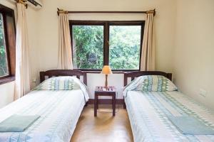 2 camas en una habitación con ventana en Kiambi Safaris Lodge, en Chiawa