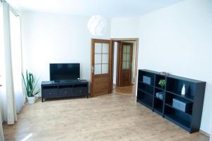 a living room with a television and a black cabinet at Center Orange house in Cēsis