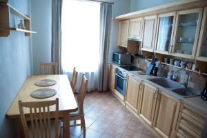 cocina con mesa, fregadero, mesa y sillas en Center Orange house en Cēsis