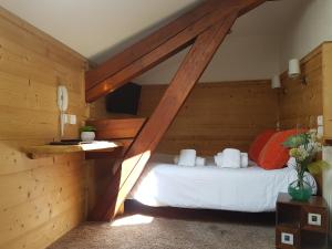 una camera con un letto in una stanza con pareti in legno di Les Campanules a Les Houches