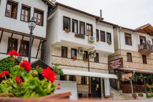 un bâtiment avec des fleurs rouges devant lui dans l'établissement Toni's Guest House, à Melnik