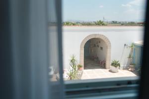 a view of a courtyard from a window at Relais Antiche Saline in Torre Nubia