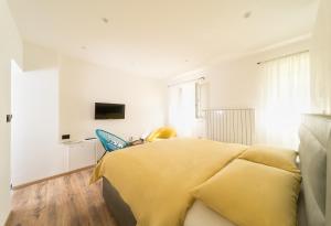 um quarto com uma cama amarela num quarto branco em Impression em Mošćenička Draga