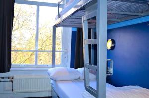 a bedroom with two bunk beds and a window at The Flying Pig Uptown in Amsterdam