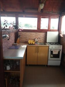 Una pequeña cocina con fregadero y estufa. en Casa Benny, en Costinesti