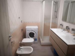 bagno con lavandino e servizi igienici e lavatrice. di Le Dimore di Emilia a Napoli