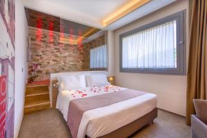 een slaapkamer met een bed en een bakstenen muur bij Boutique Hotel Bramante & SPA in Urbania