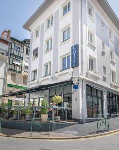 un gran edificio blanco con plantas delante en Hôtel Cosmopolitain, en Biarritz