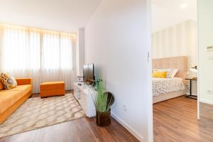 een woonkamer met een bank en een bed bij Ceuta Inn Porto in Porto