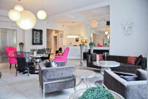ニースにあるオテル ラ ヴィラ ニース ヴィクトル ユーゴのリビングルーム(ソファ、テーブル、ピンクの椅子付)