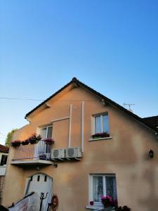a building with two windows and two balconies at Chambres d'Hôtes Chez Marilou in Aulnay-sous-Bois