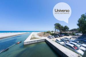 a group of cars parked in a parking lot next to the beach at Hotel Universo in Otranto