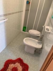 a bathroom with a toilet and a red rug on the floor at B&B Collemare in Drapia