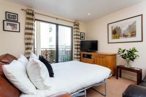 a bedroom with a large bed and a television at Veeve - Contemporary by Regent's Canal in London