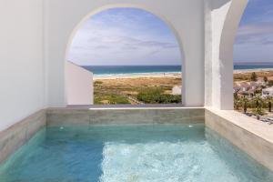 a swimming pool with an ocean view from a house at Zahara Beach & Spa by QHotels - Adults Recommended in Zahara de los Atunes