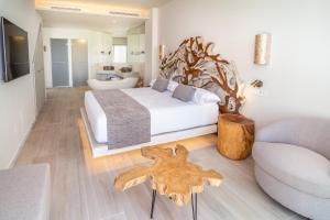 a bedroom with a white bed and a wooden table at Zahara Beach & Spa by QHotels - Adults Recommended in Zahara de los Atunes