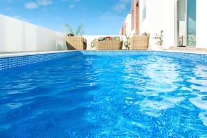 een zwembad met blauw water in een gebouw bij Villa Carmen in Protaras