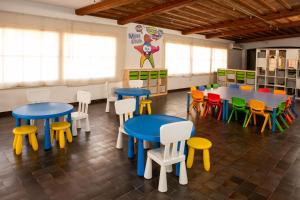 a classroom with tables and chairs in a room with windows at RVHotels Nieves Mar in L'Escala