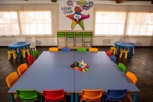 a classroom with a blue table and colorful chairs at RVHotels Nieves Mar in L'Escala