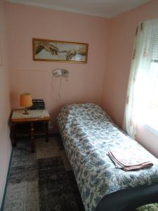 a small bedroom with a bed and a table at Peaceful Farm in Bøstad