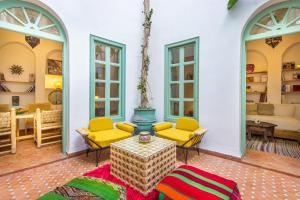 sala de estar con sillas amarillas y mesa en Riad Helen en Marrakech