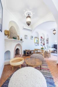ein Wohnzimmer mit einem Kamin und einem Tisch in der Unterkunft Riad Helen in Marrakesch