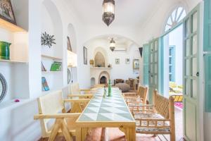 una sala da pranzo con tavolo e sedie di Riad Helen a Marrakech