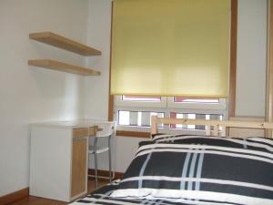 1 dormitorio con 1 cama en blanco y negro y escritorio en Apartamento en 1ª línea de la Playa de Covas - Viveiro (Lugo), en Viveiro