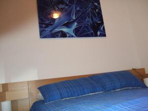 Un dormitorio con una cama azul con una foto en la pared en Apartamento en 1ª línea de la Playa de Covas - Viveiro (Lugo), en Viveiro 13 fotos más