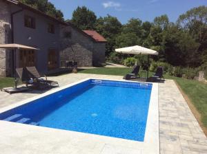 una piscina frente a una casa en Villa Anton - The Old Dairy en Hrušica