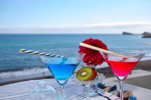 two cocktails on a table with the ocean in the background at Aparthotel Barracuda in Ponta Delgada