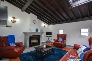 a living room with leather furniture and a fireplace at Aparthotel Barracuda in Ponta Delgada