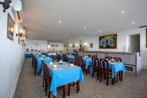 a dining room with blue tables and chairs in a restaurant at Aparthotel Barracuda in Ponta Delgada