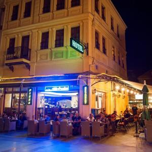 a group of people sitting at tables outside of a building at Hotel Treff in Bitola