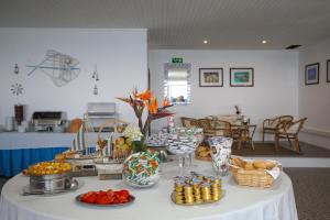 a table with a white table cloth with food on it at Aparthotel Barracuda in Ponta Delgada