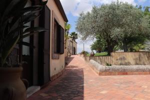 a brick alley way with a building and trees at Tenuta Aguglia in Noto