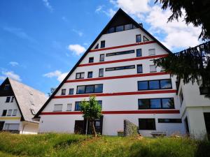 een groot wit gebouw met een gambrel dak bij Ferienwohnung Lydia in Schönwald