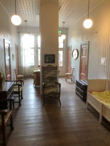 a room with chairs and tables and a clock on the wall at Siaröfortet Skärgårdskrog och Pensionat in Norra Ljustero